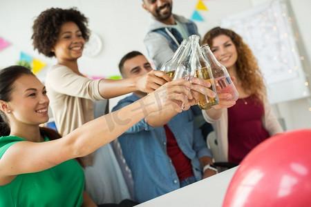企业,庆典和假期概念-快乐的同事在办公室聚会上用非酒精饮料叮当作响